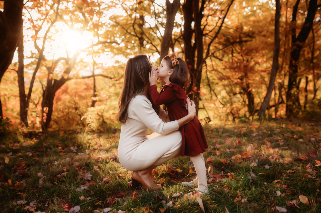 Daughter kisses her mother during Family Photoshoot. 