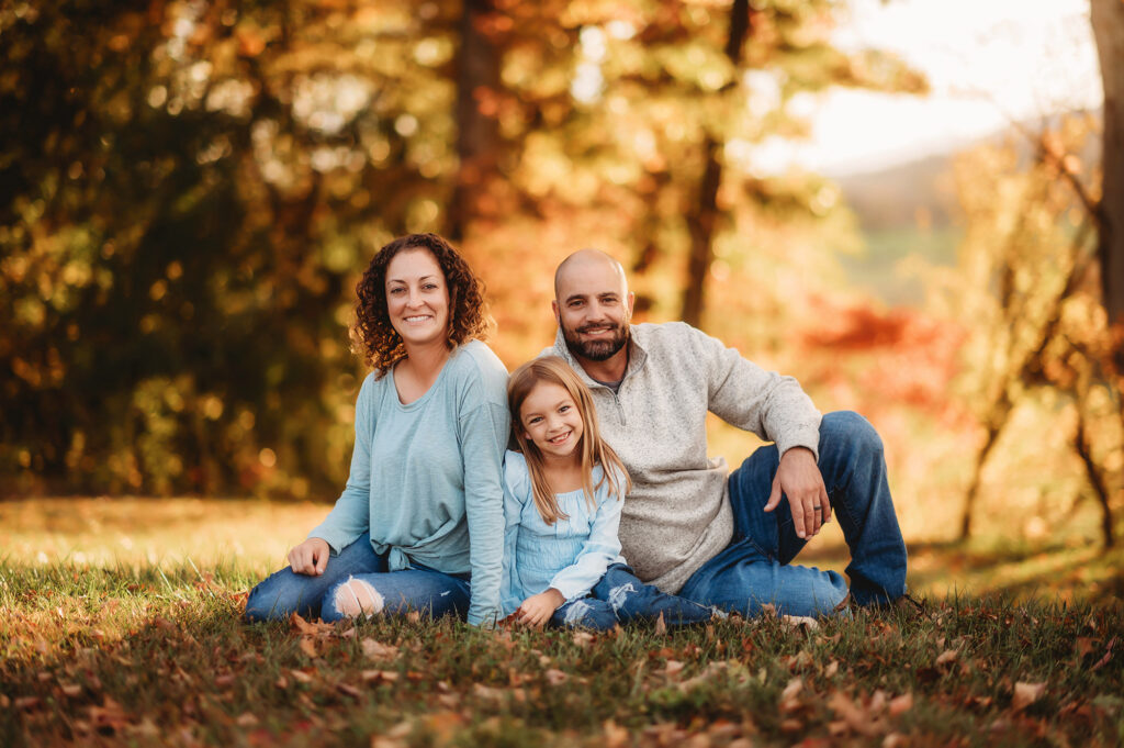 Family sits together during Fall Family Photos in Asheville, NC after learning about the best Family Photo Locations in Asheville.