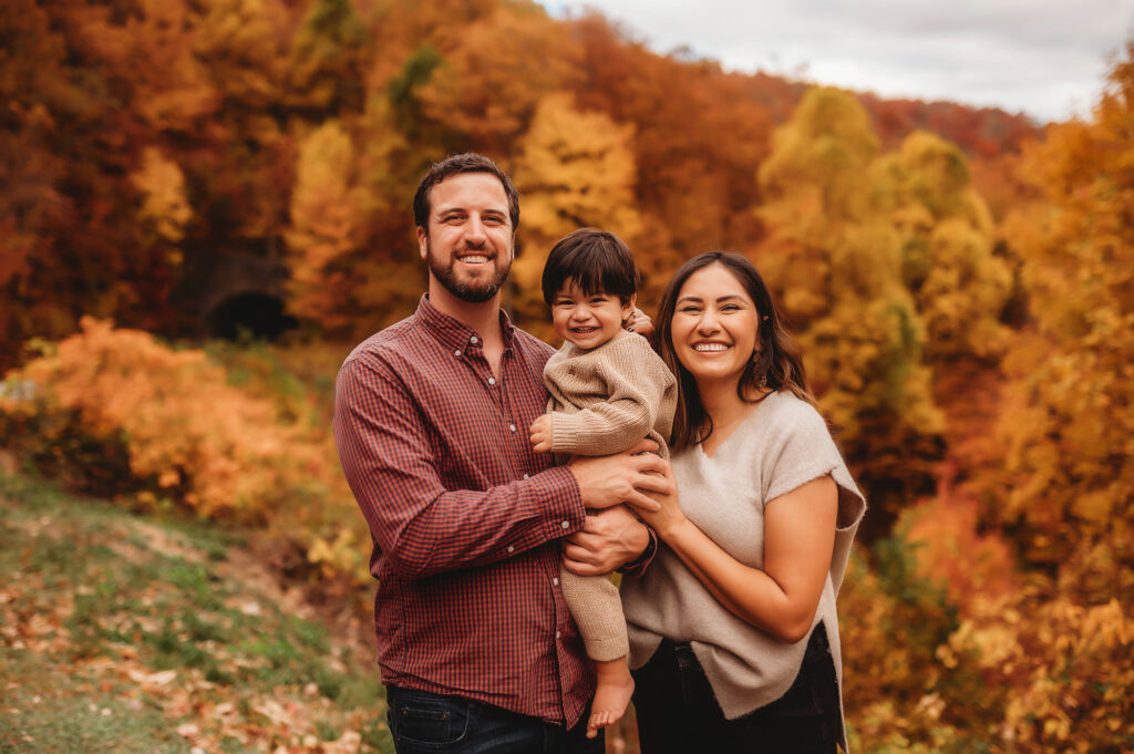 Family poses together for a Family Portrait Session in the Fall on the Blue Ridge Parkway in Asheville, NC after visiting the Top 5 Must Visit Playgrounds in Asheville, NC.