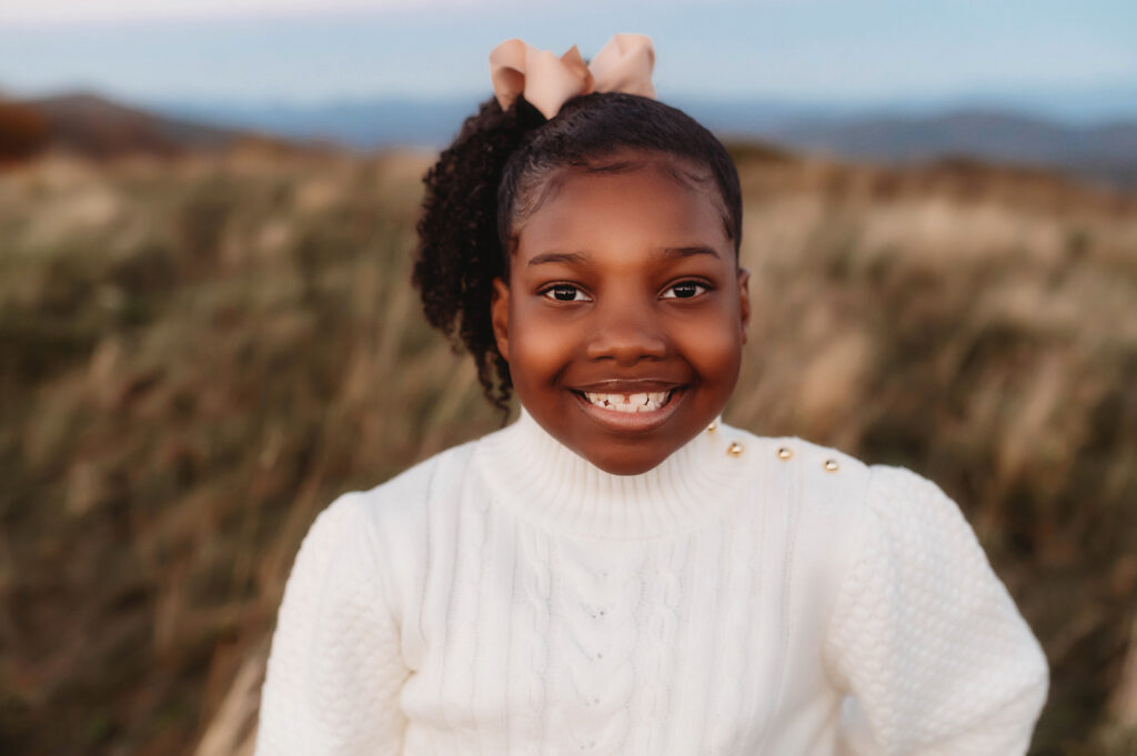 Little girl smiles into the camera during her Family Photoshoot at Max Patch.