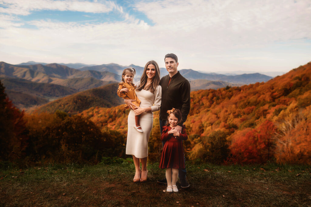 Family poses for Fall Family Photos on the Blue Ridge Parkway outside of Asheville, NC.