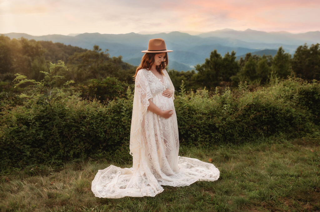 Expectant mother embraces her pregnant belly during Maternity Portrait Session on the Blue Ridge Parkway in Asheville, NC.