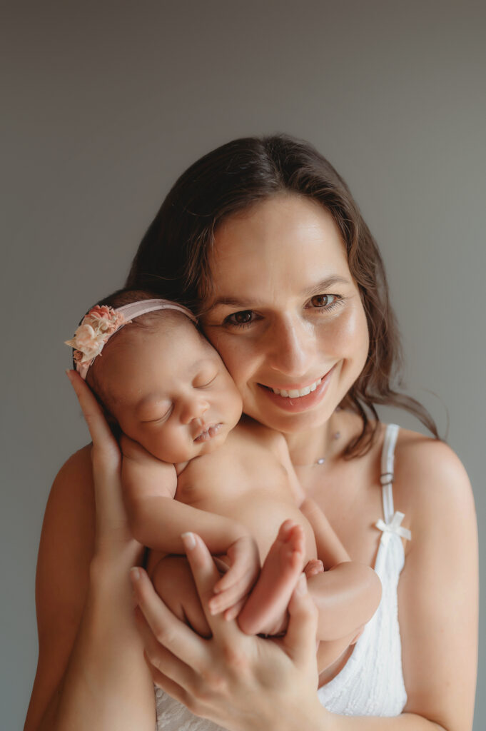 Mother embraces her infant daughter during Newborn Pictures in Asheville, NC.