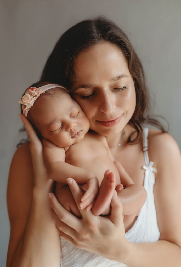 Mother embraces her infant daughter during Newborn Pictures in Asheville, NC.