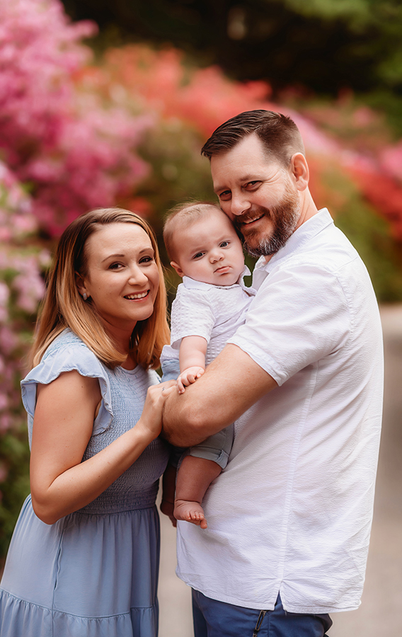 Parents embrace their baby during Family Photos at Biltmore Estate in the Spring. 
